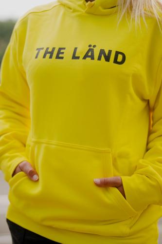 Gelber Kapuzenpullover mit der Aufschrift THE LÄND