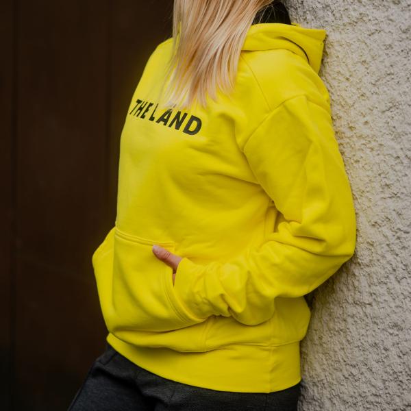 Gelber Kapuzenpullover mit der Aufschrift THE LÄND