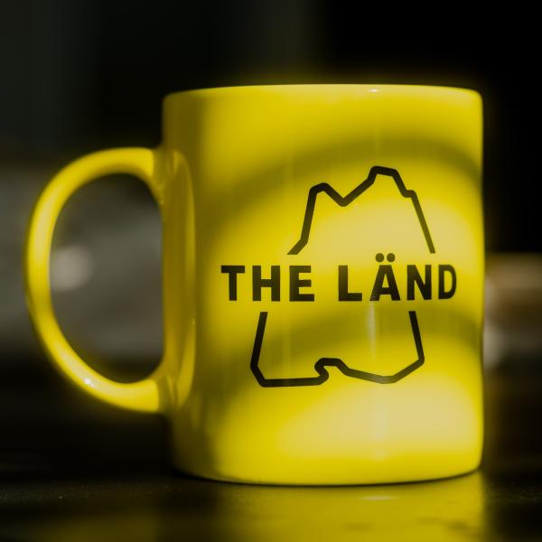 Gelbe Tasse mit THE LÄND Logo